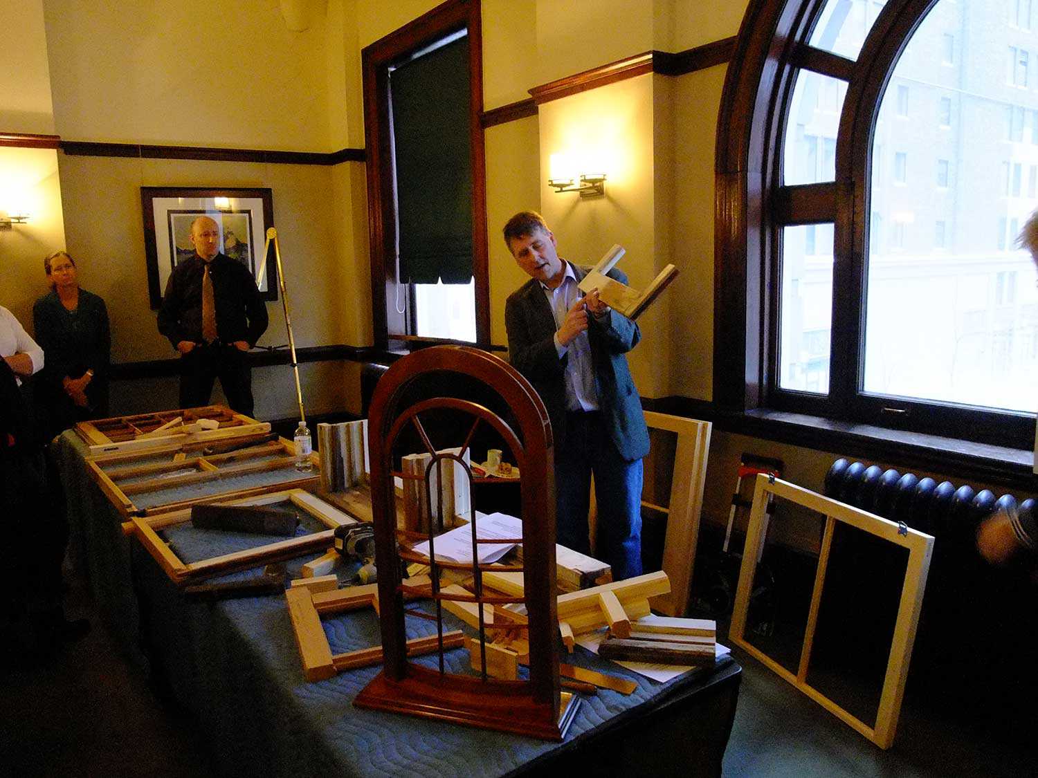 Wood conservator and master craftsman Alan Stacey instructing heritage staff in traditional preservation techniques at the Ontario Heritage Centre.