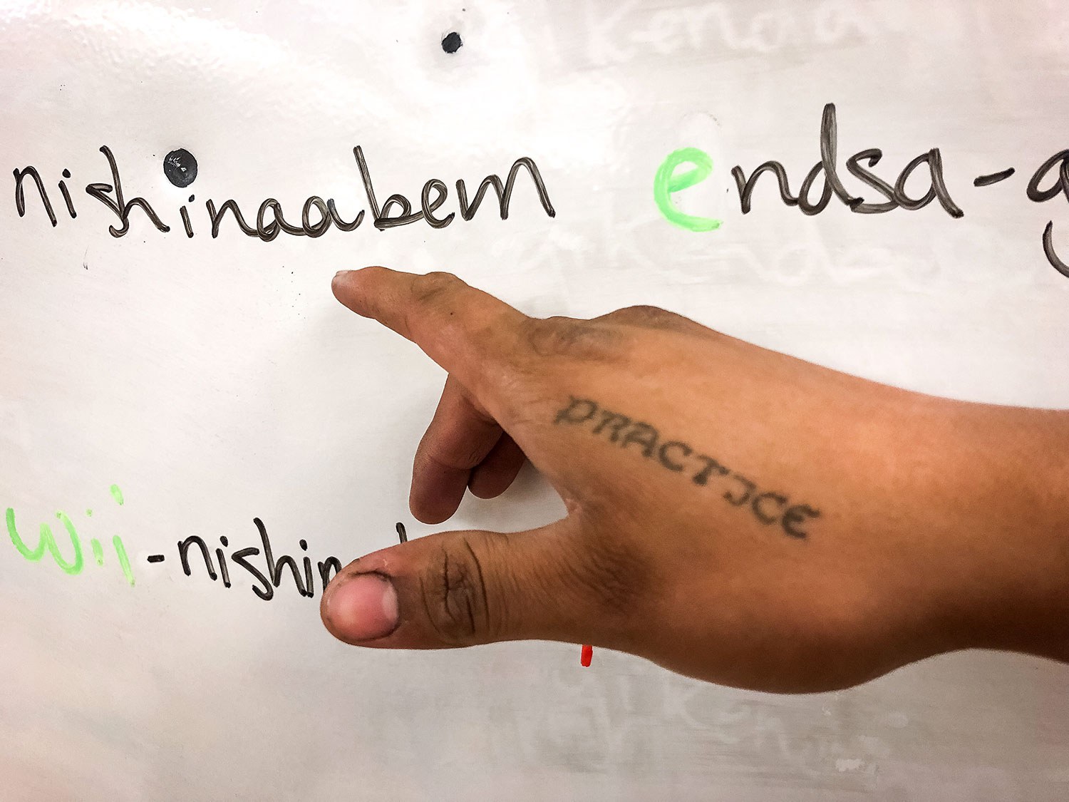 A tattoo on instructor Ninaatig Pangowish’s hand makes for an ever-present reminder for ‘practice’ in speaking the language.